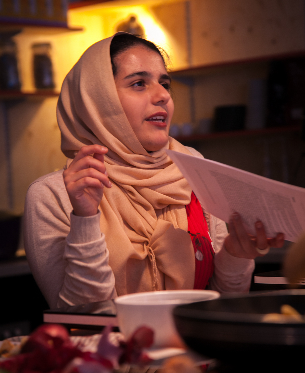 A woman wearing a beige scarf while attending a London Cookery Class hosted by Migrateful.