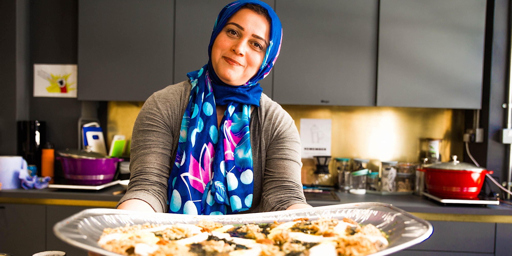 A woman in a hijab showcasing her culinary skills during a London Cookery Class.