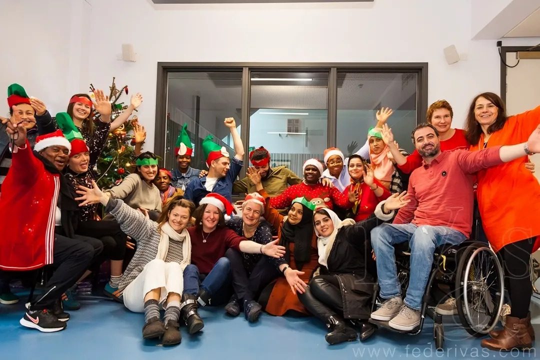 A group of people in Christmas hats posing for a festive photo at Migrateful's London Cookery Class.