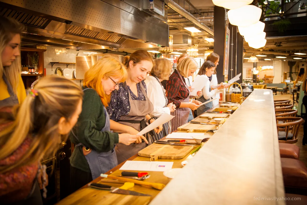 Migrateful hosts a London Cookery Class where a group of people come together in a kitchen to prepare delicious food.
