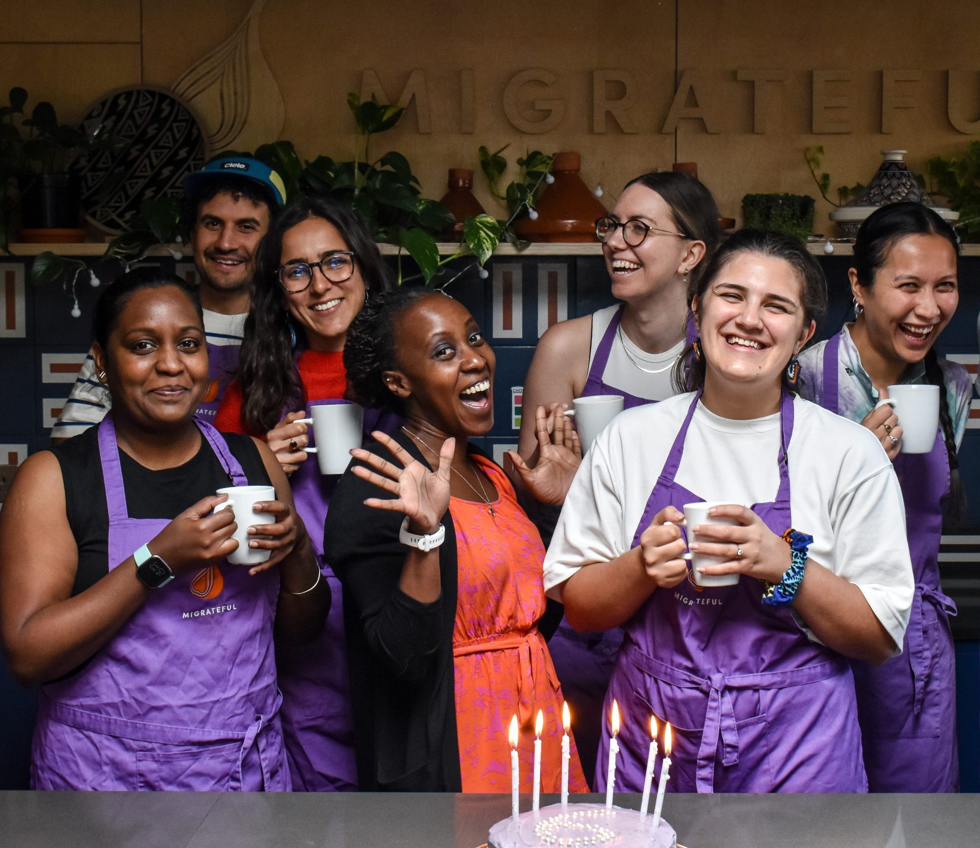 A group of people posing for a photo in front of a cake.