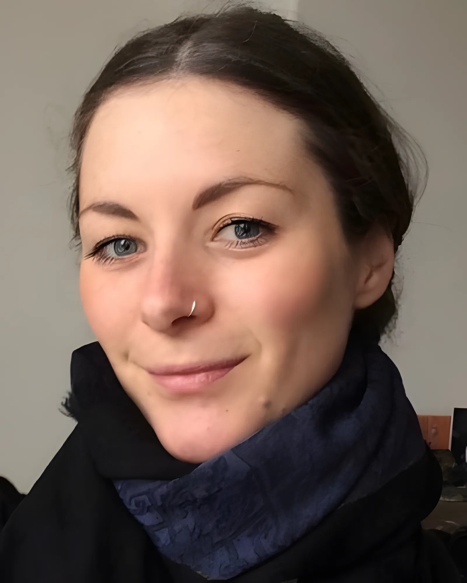 A woman wearing a scarf attends a Migrateful London Cookery Class, showcasing her unique piercing.