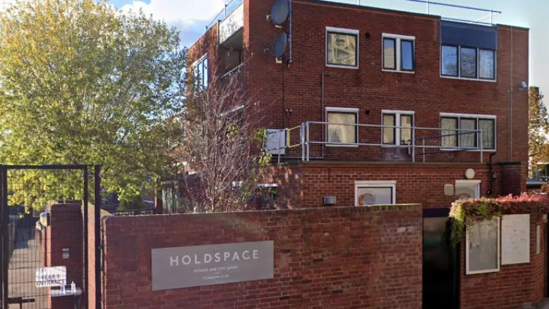 A Migrateful brick building in London with a sign on it.