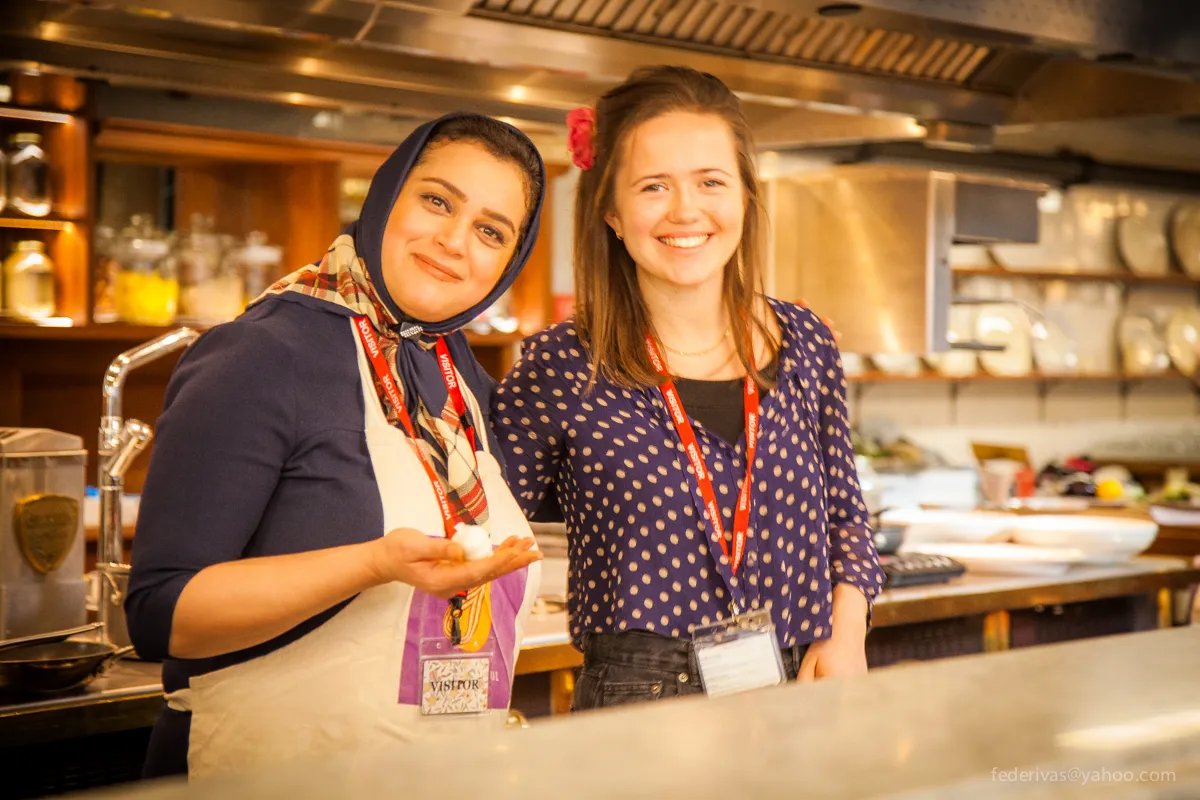 Jess, the migrateful founder standing next to the first student in a Migrateful kitchen