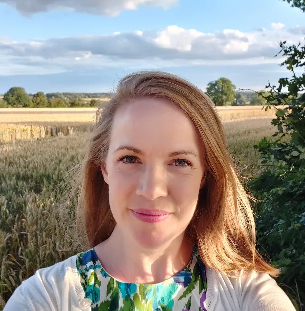 A woman taking a selfie in front of a wheat field during her London Cookery Class.